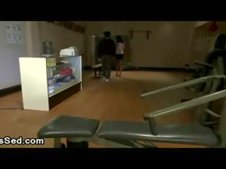 Brunette tranny sucks putz and gives footjob in gym